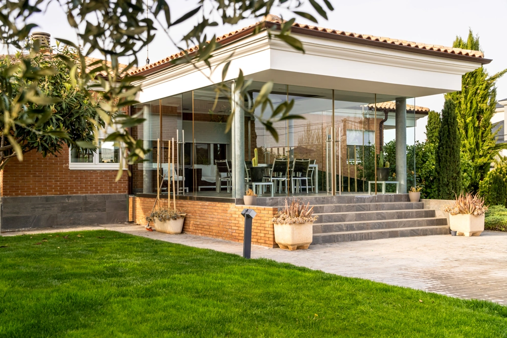 Nowoczesna zabudowa tarasu ze szklanymi ścianami i schodami, zielony trawnik Tarasy