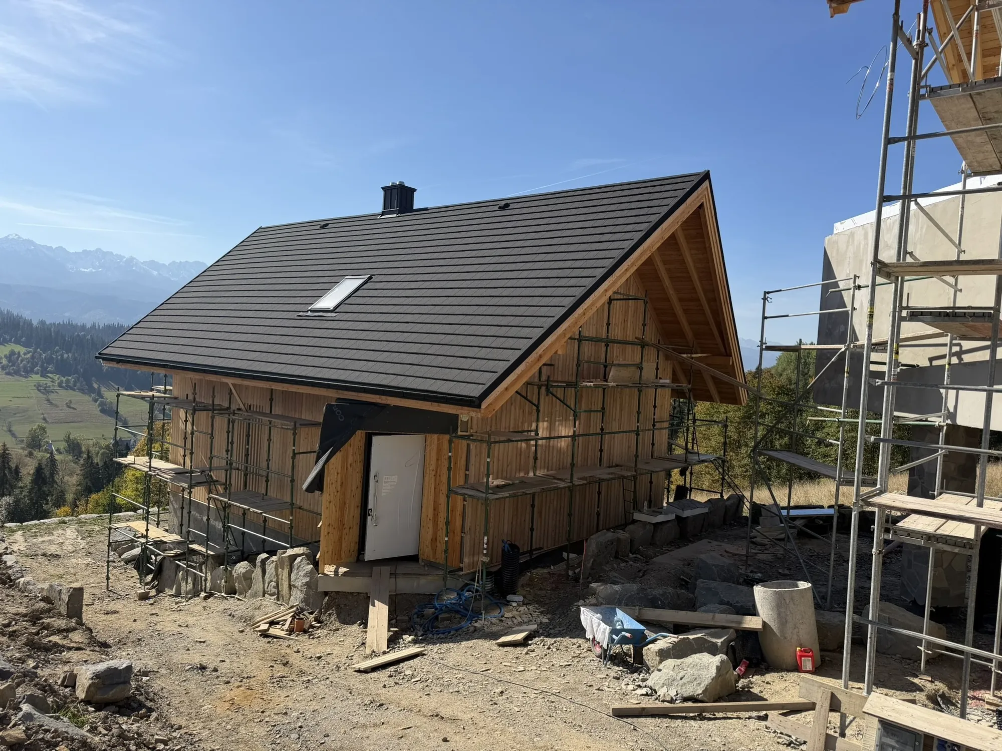 Dom z czarnym dachem i drewnianą elewacją na tle Tatr – Gliczarów Górny, Megatall
